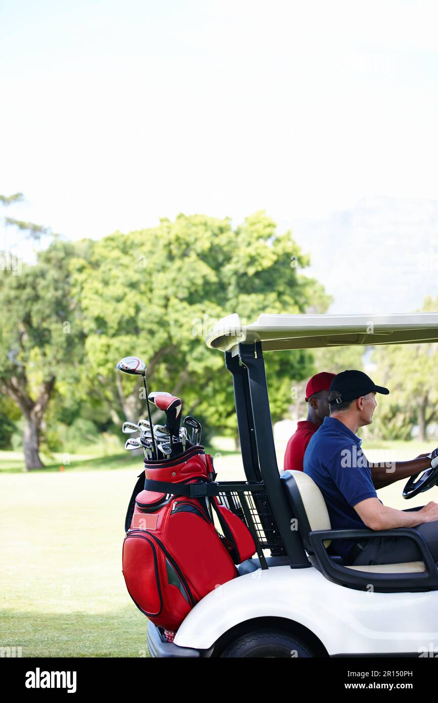 On the hunt for a missing ball. two men in a cart driving across a golf