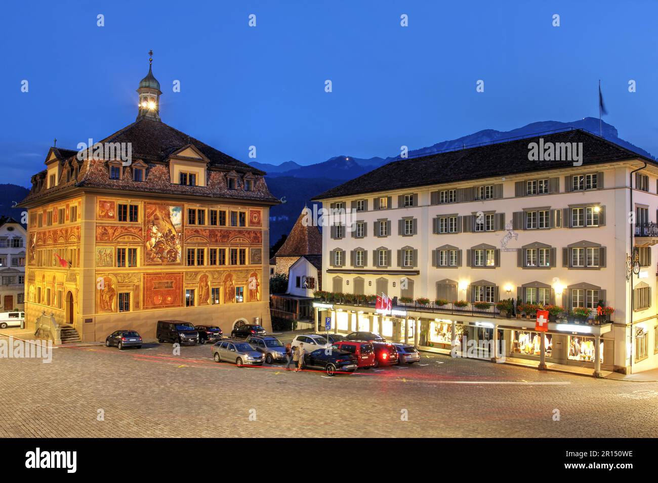 The Town Hall (Rathaus) of Schwyz city in central Switzerland with distinctive murals in Hauptplatz square during a summer evening. Stock Photo