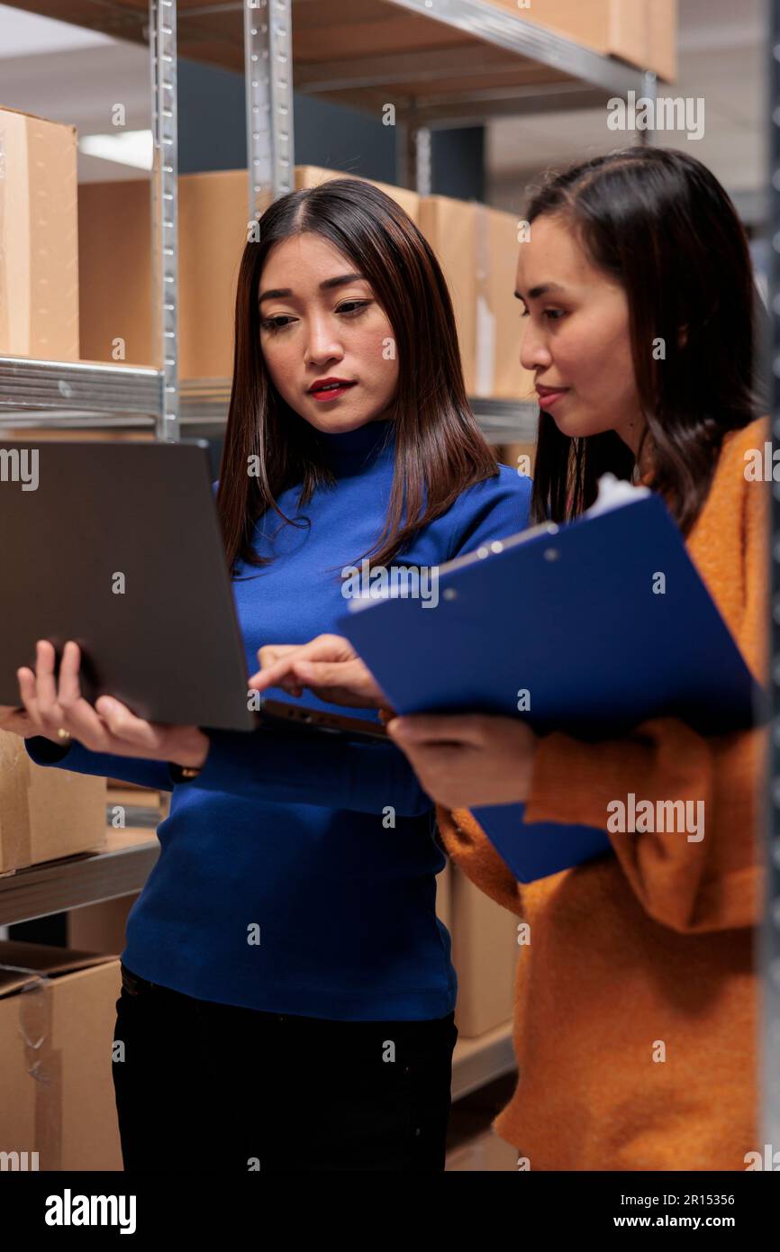 Warehouse managers checking product inventory analysis report data on