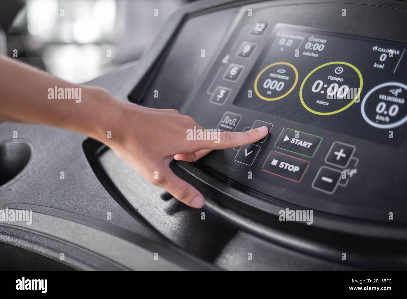 details of hand pressing buttons of the control panel of a treadmill, gym machines for cardio, objects and technology with modern design Stock Photo