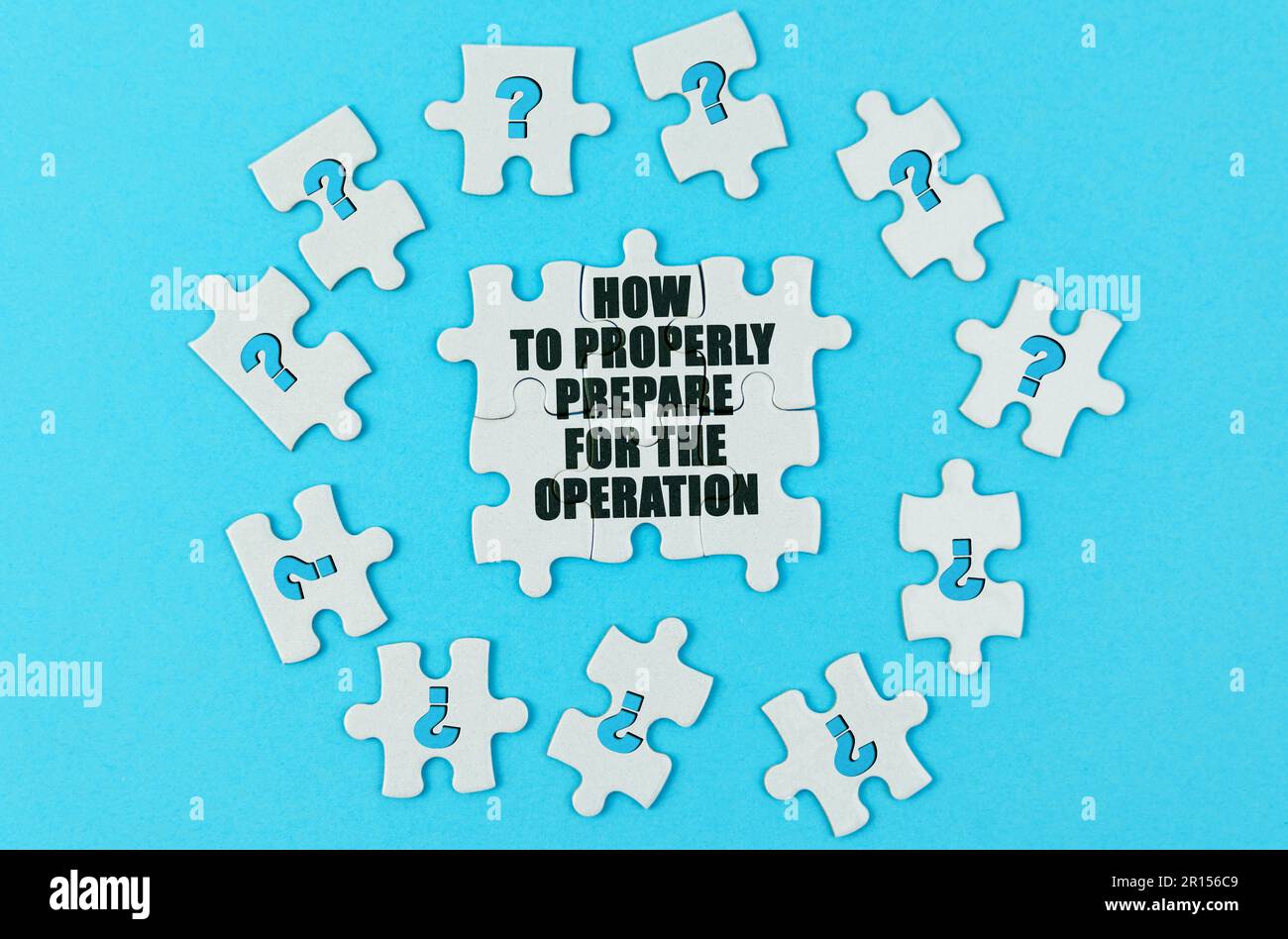 Medical concept. On a blue surface are puzzles with a question mark, in the center with the inscription - How to properly prepare for the operation Stock Photo