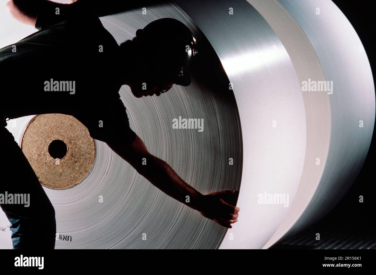 Paper mill worker checking a large role findeprinting paper Stock Photo