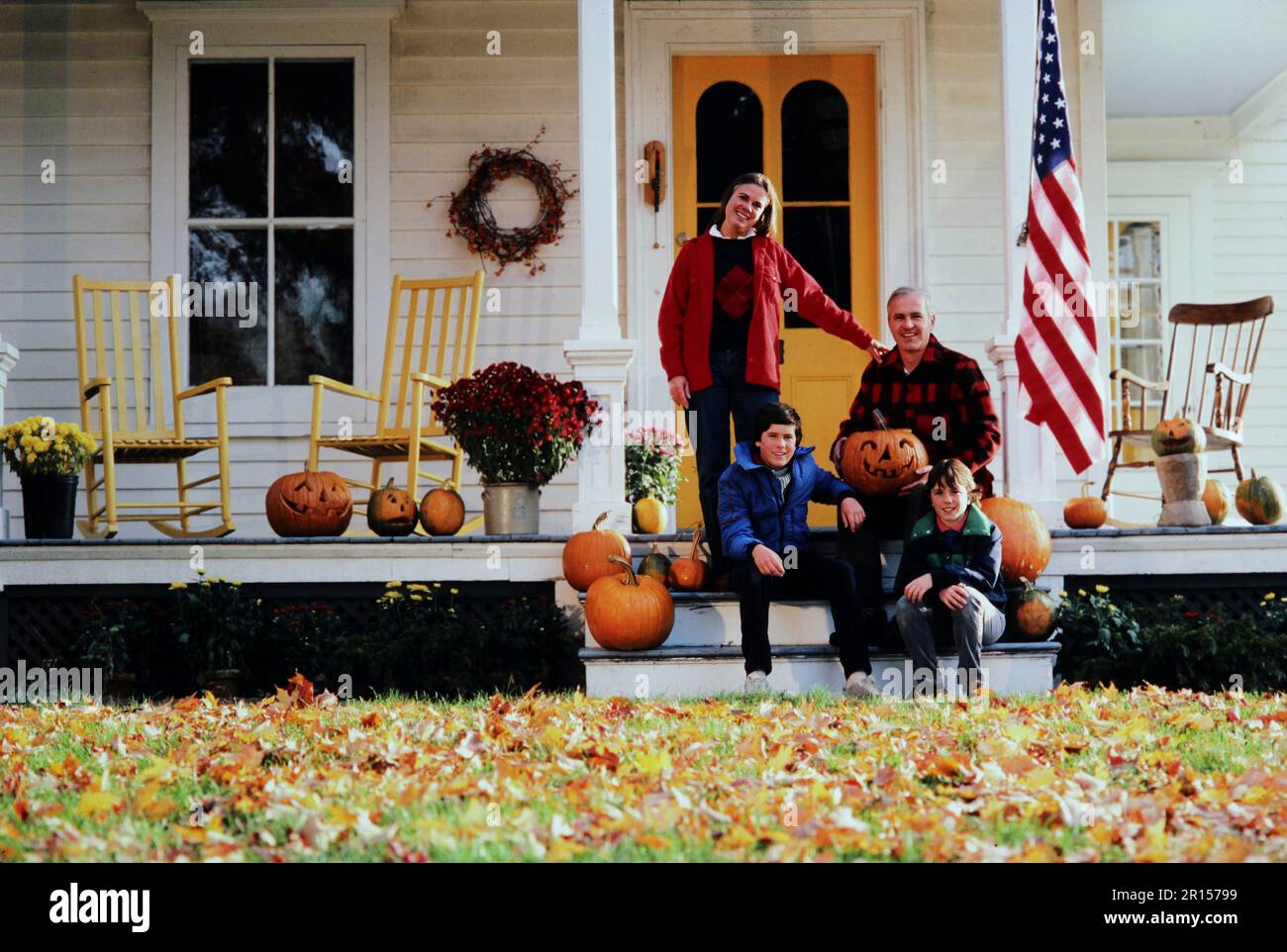 Family Portrait of a Caucasian family posing on the steps of there 19th century home in the fall Stock Photo