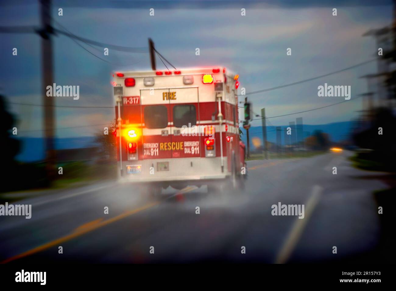 Ambulance racing down a rainy rural road Stock Photo