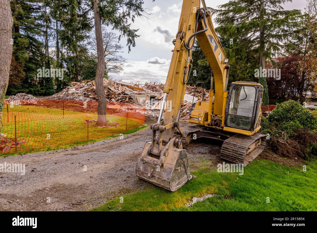 A digger next to a house demolished to make room for new construction