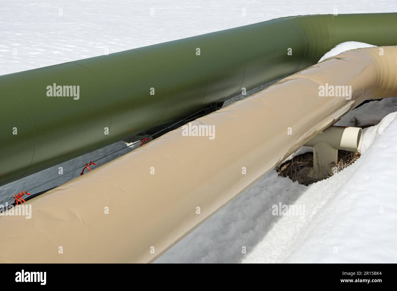 green and beige geothermal hot water pipelines in the snow Stock Photo