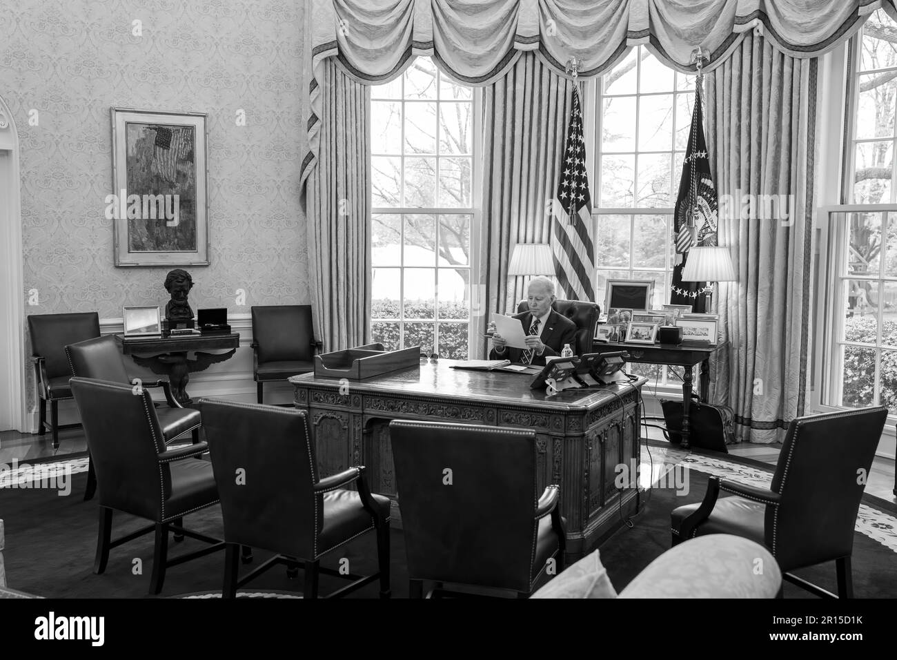President Joe Biden reads his notes at the Resolute Desk, Thursday