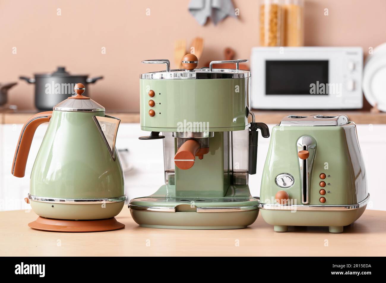 https://c8.alamy.com/comp/2R15EDA/electric-kettle-modern-coffee-machine-and-toaster-on-wooden-table-in-kitchen-2R15EDA.jpg