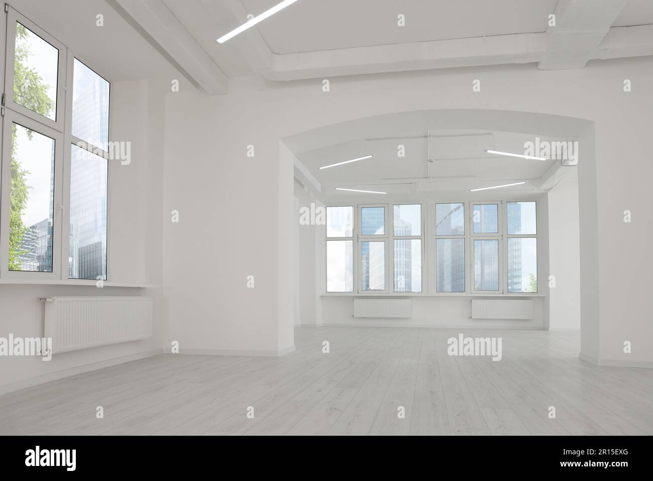 Empty office room with white walls, clean windows and modern lights on ceiling. Interior design Stock Photo