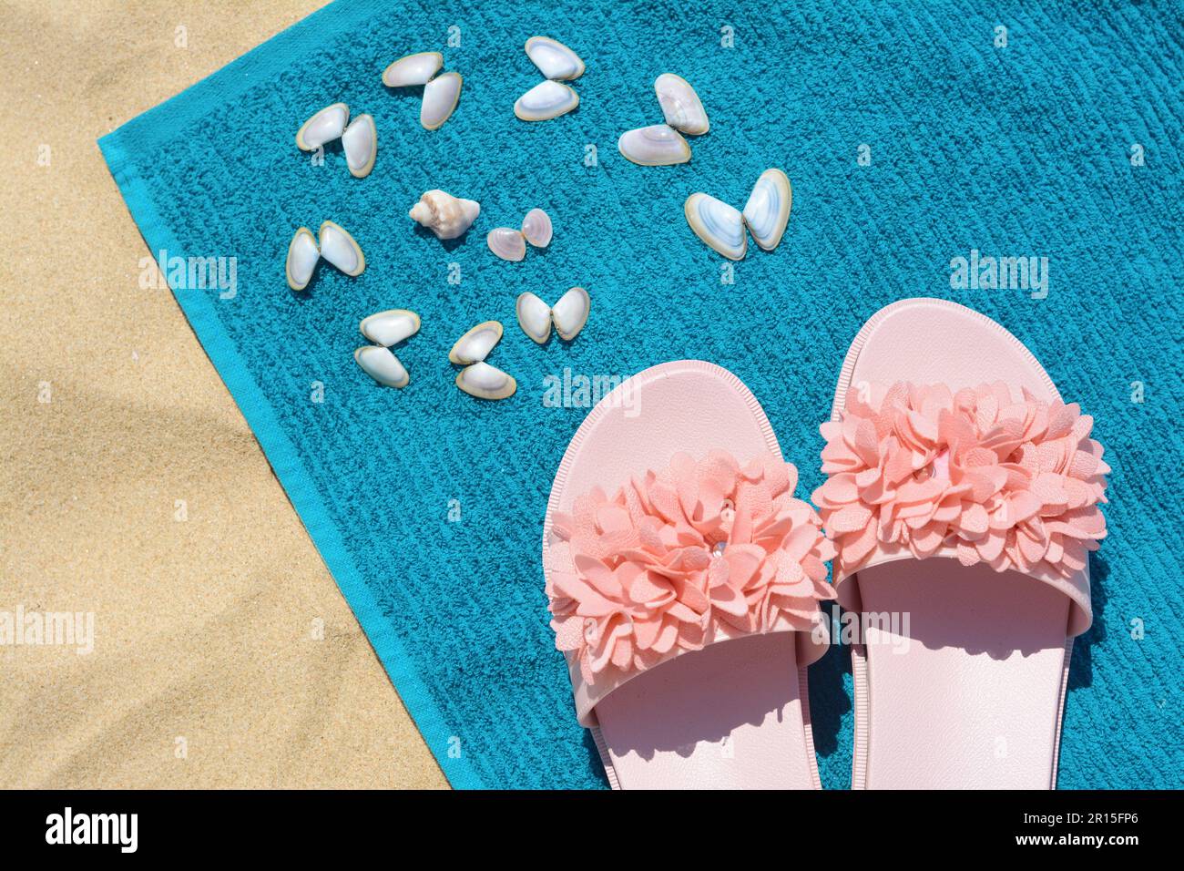 Towel, seashells and flip flops on sand, top view. Beach accessories ...