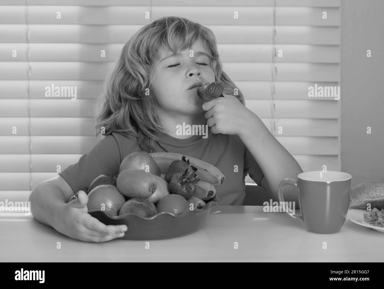 Child with strawberry, summer fruits. Little child boy having healthy