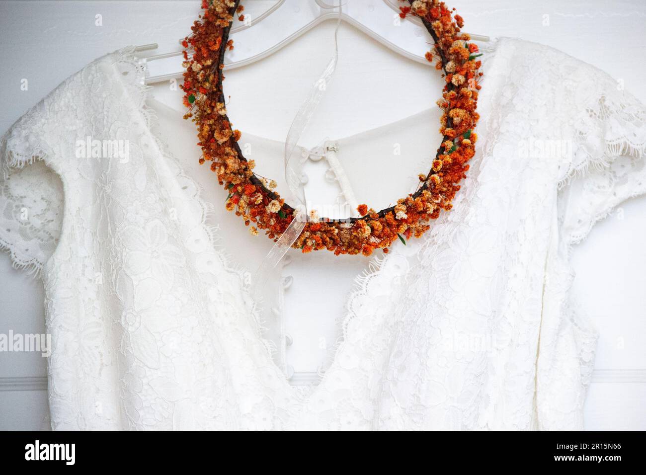 close up hanging white wedding dress bodice close up with orange head ...