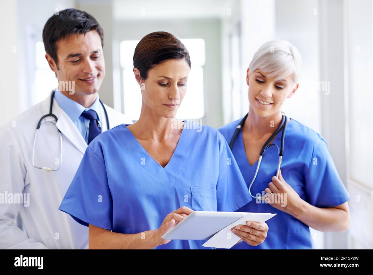 All the patients history at her fingertips. three young doctors going ...