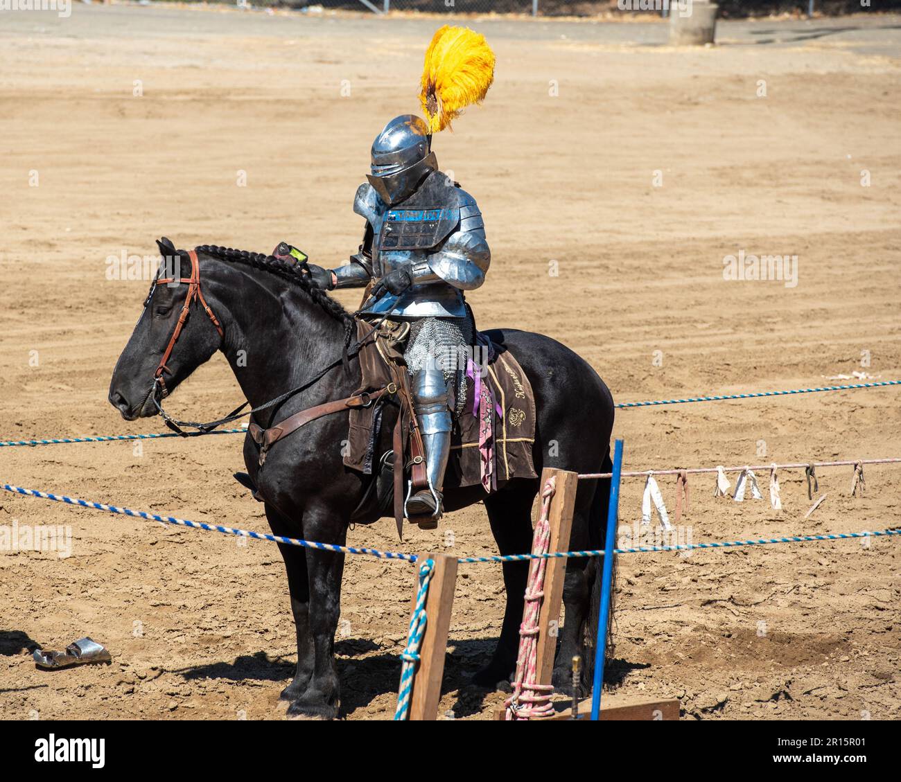 Folsom, CA, September 24, 2022. Unidentified young male at the Folsom Renaissance Faire dressed as a knight ridig a black horse in the arena Stock Photo