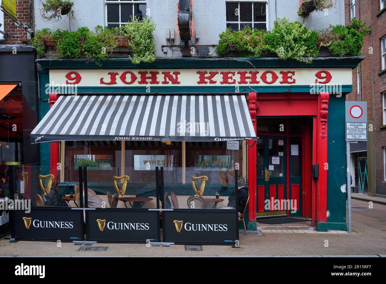 Colorful Dublin pub with outdoor seating under a striped awning Stock Photo