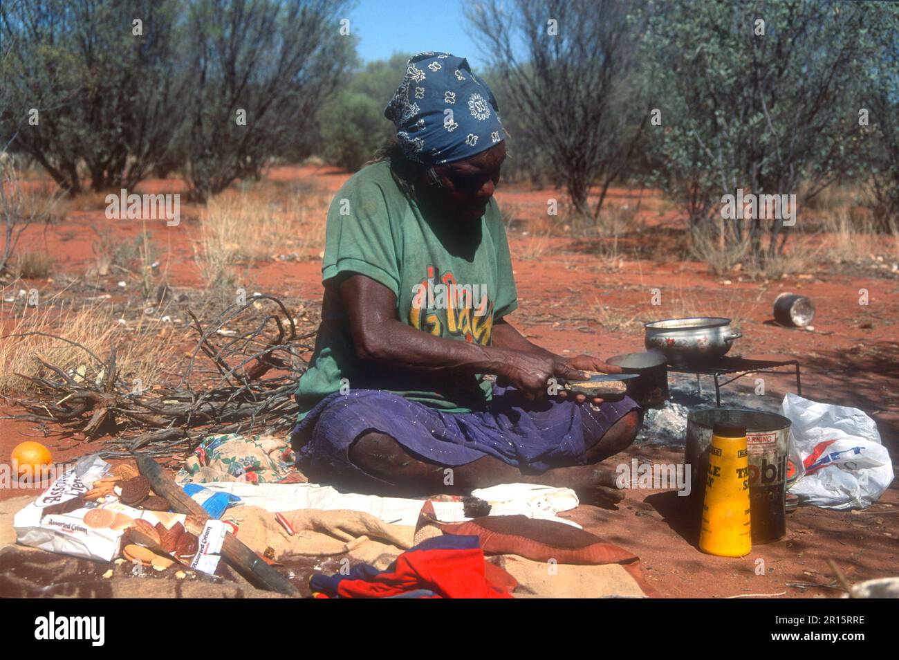Aboriginal woman preparing bush tucker food in an outdoors setting