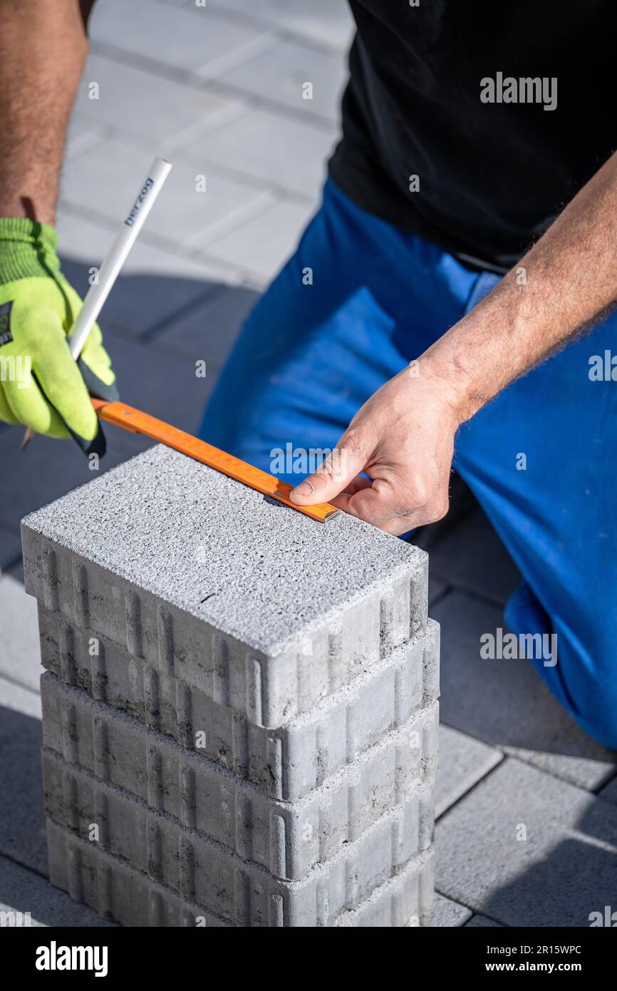 Man measuring stones for natural stone paving, on construction site