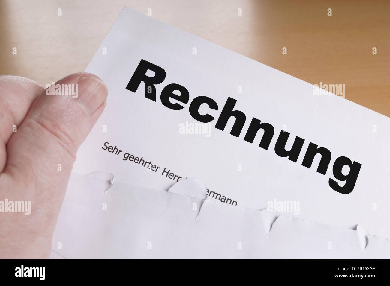 Rechnung hand holding german invoice letter with opened envelope Stock Photo