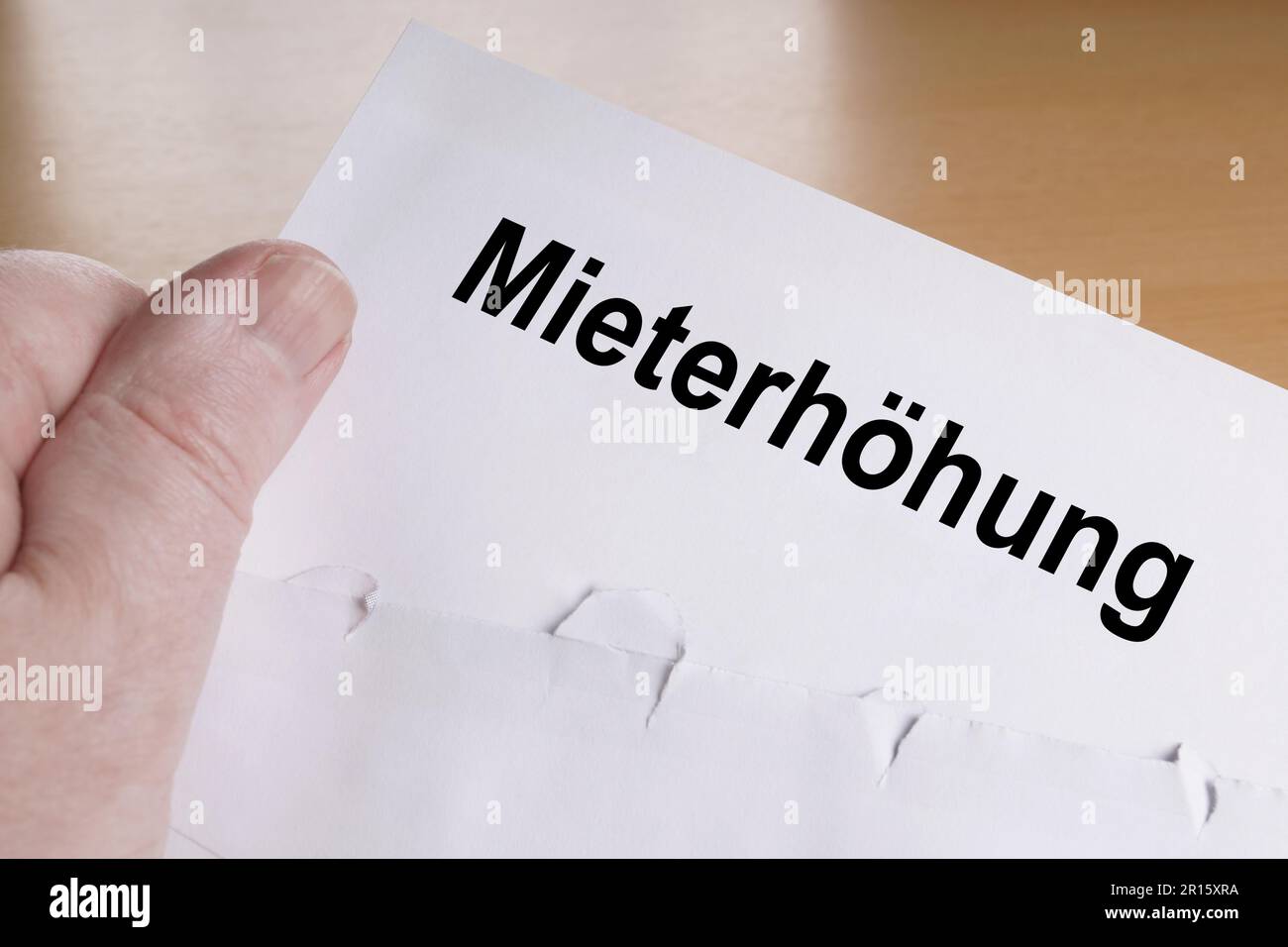 Mieterhoehung is German for rent increase, hand holding letter Stock Photo