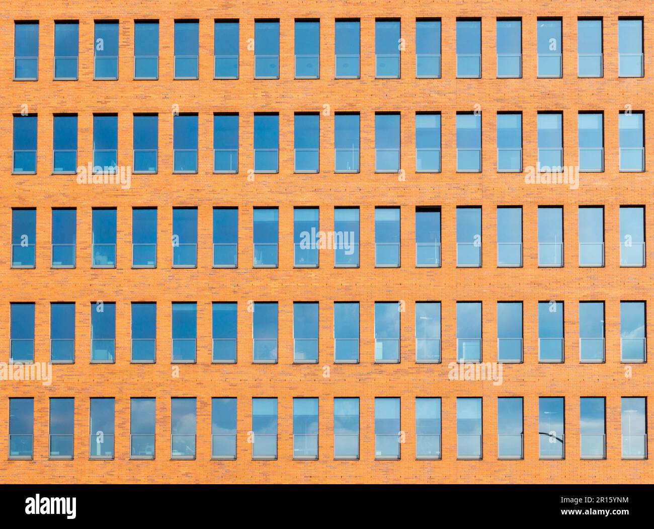 Background of an orange brick wall with many windows Stock Photo