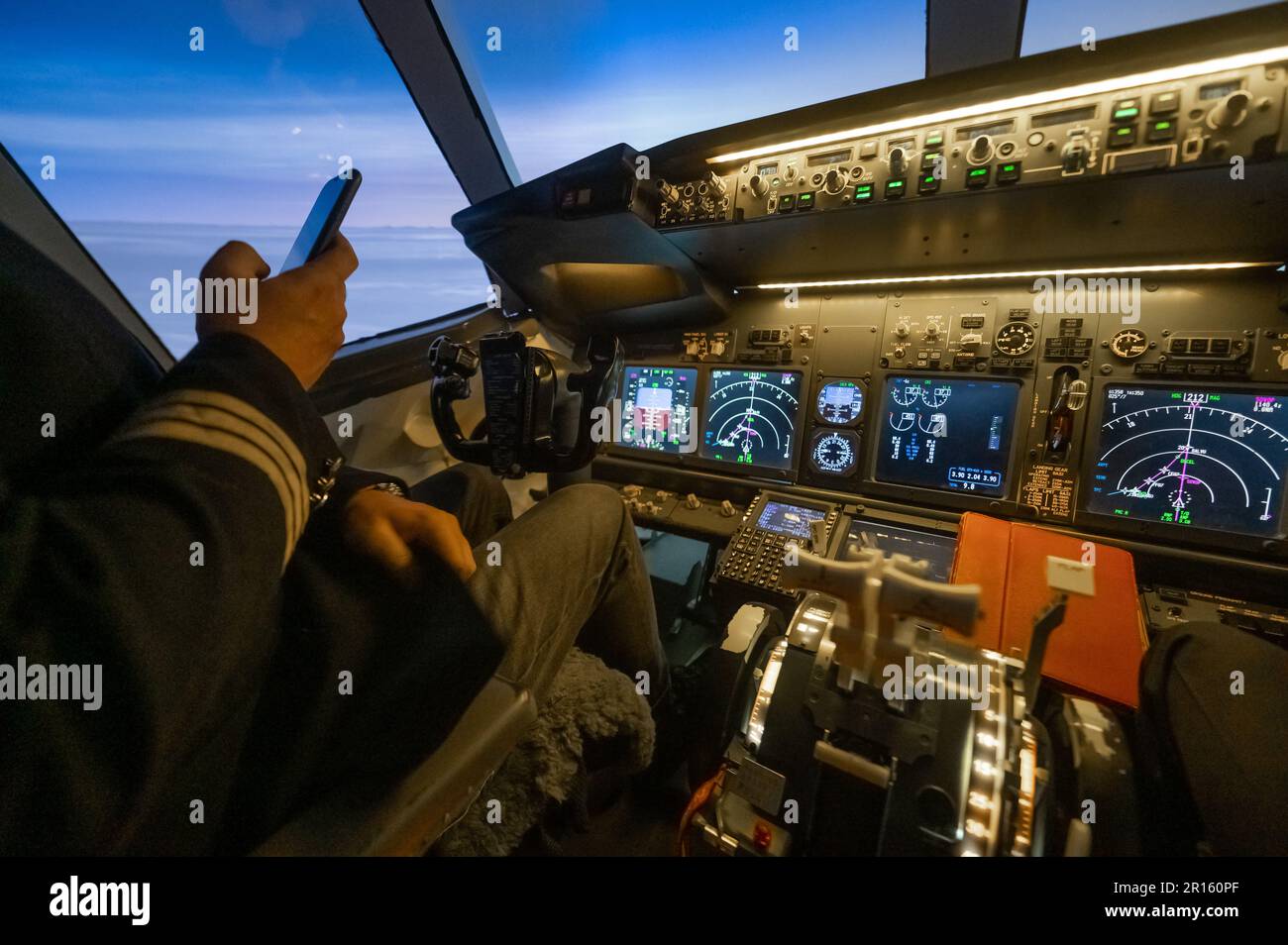 The pilot uses a smartphone while flying the plane. Autopilot Stock