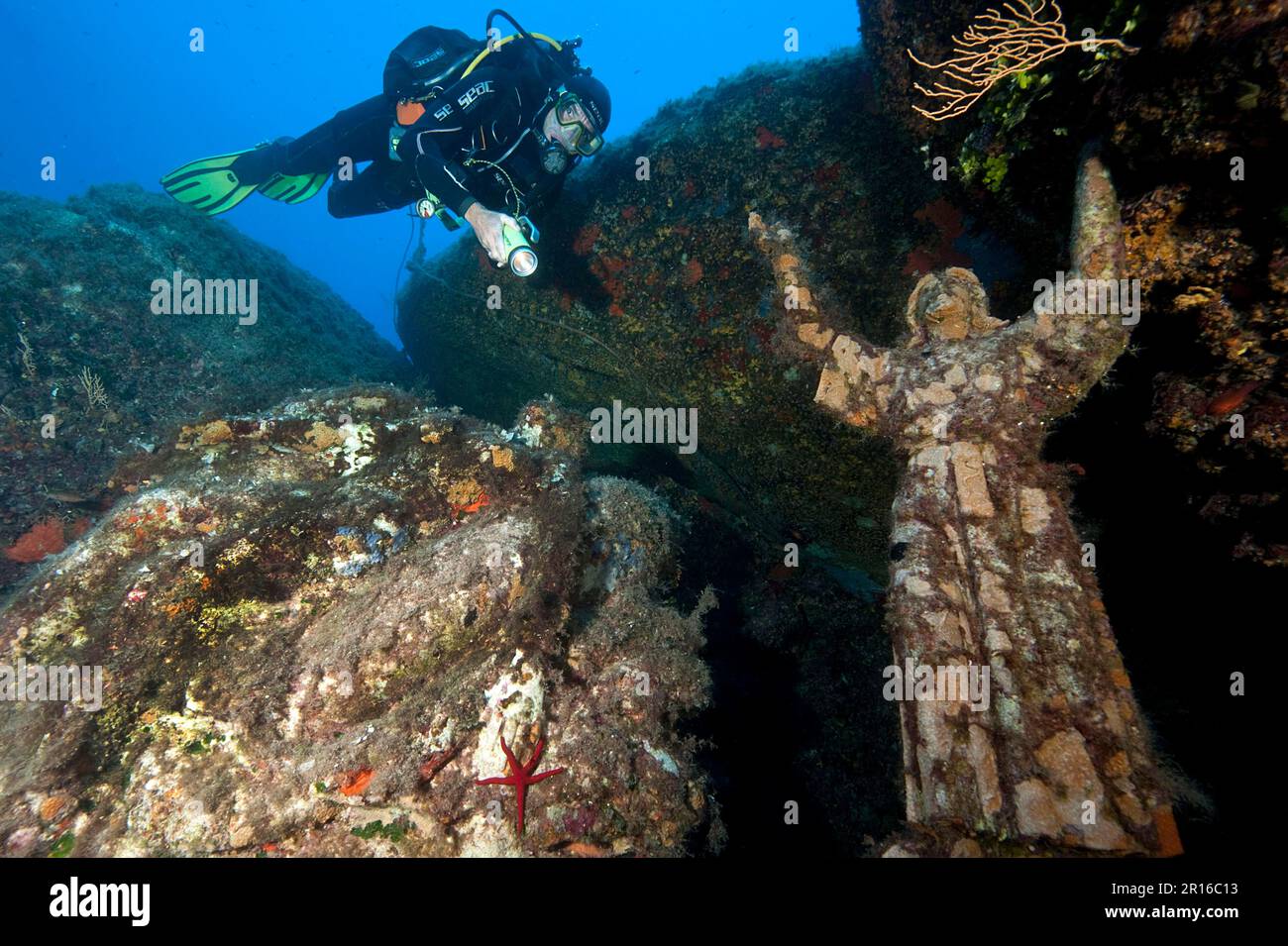 Diver next to Christ Statue, Europe, Porto, Le Scole Dive Site, Underwater Giglio Island, Tuscany, Italy Stock Photo