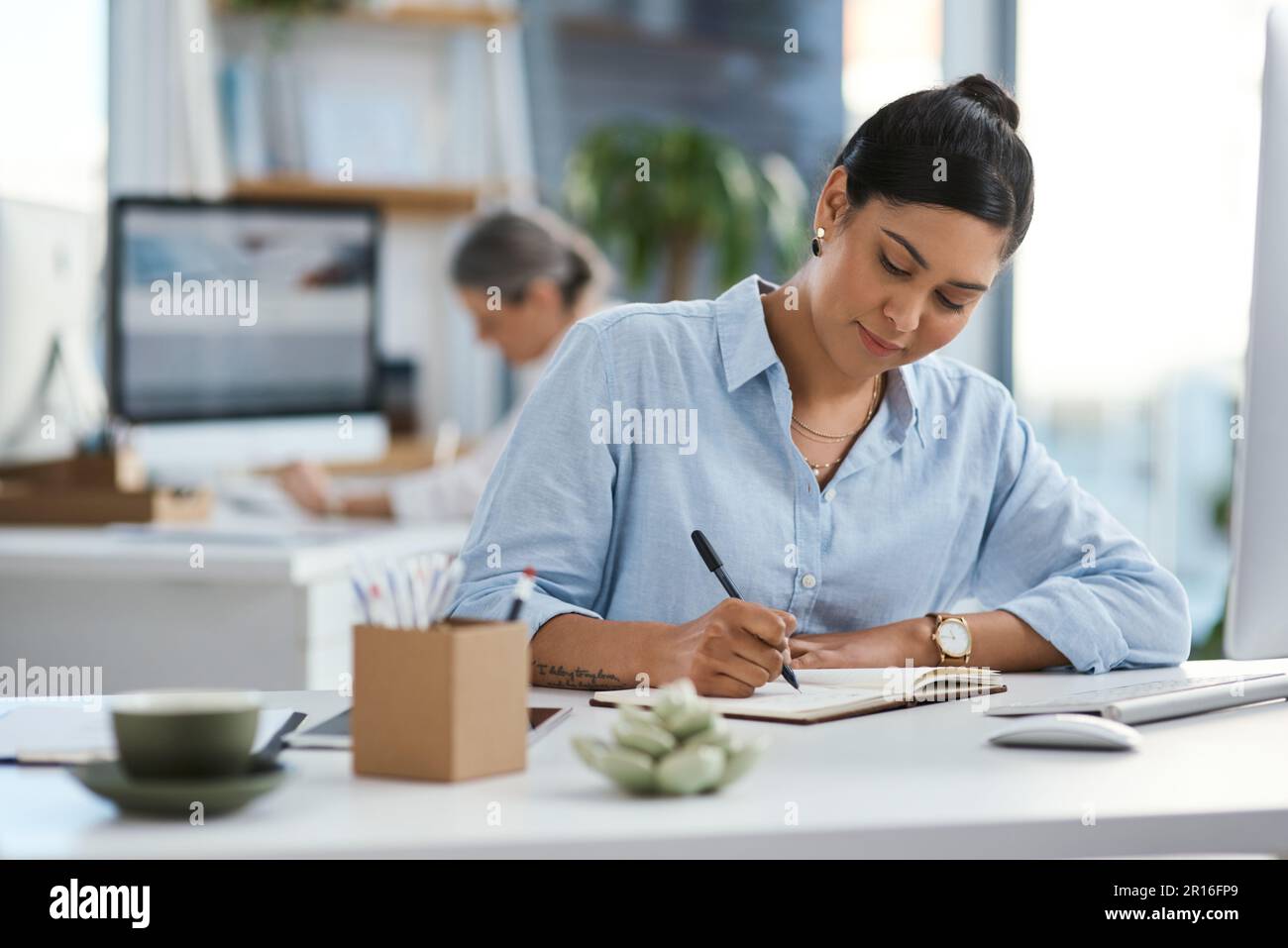 Taking notes to follow up on later. a young businesswoman writing notes ...