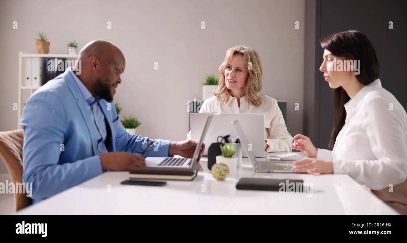 Group Of Businesspeople Sitting In Office During Business Meeting Stock ...