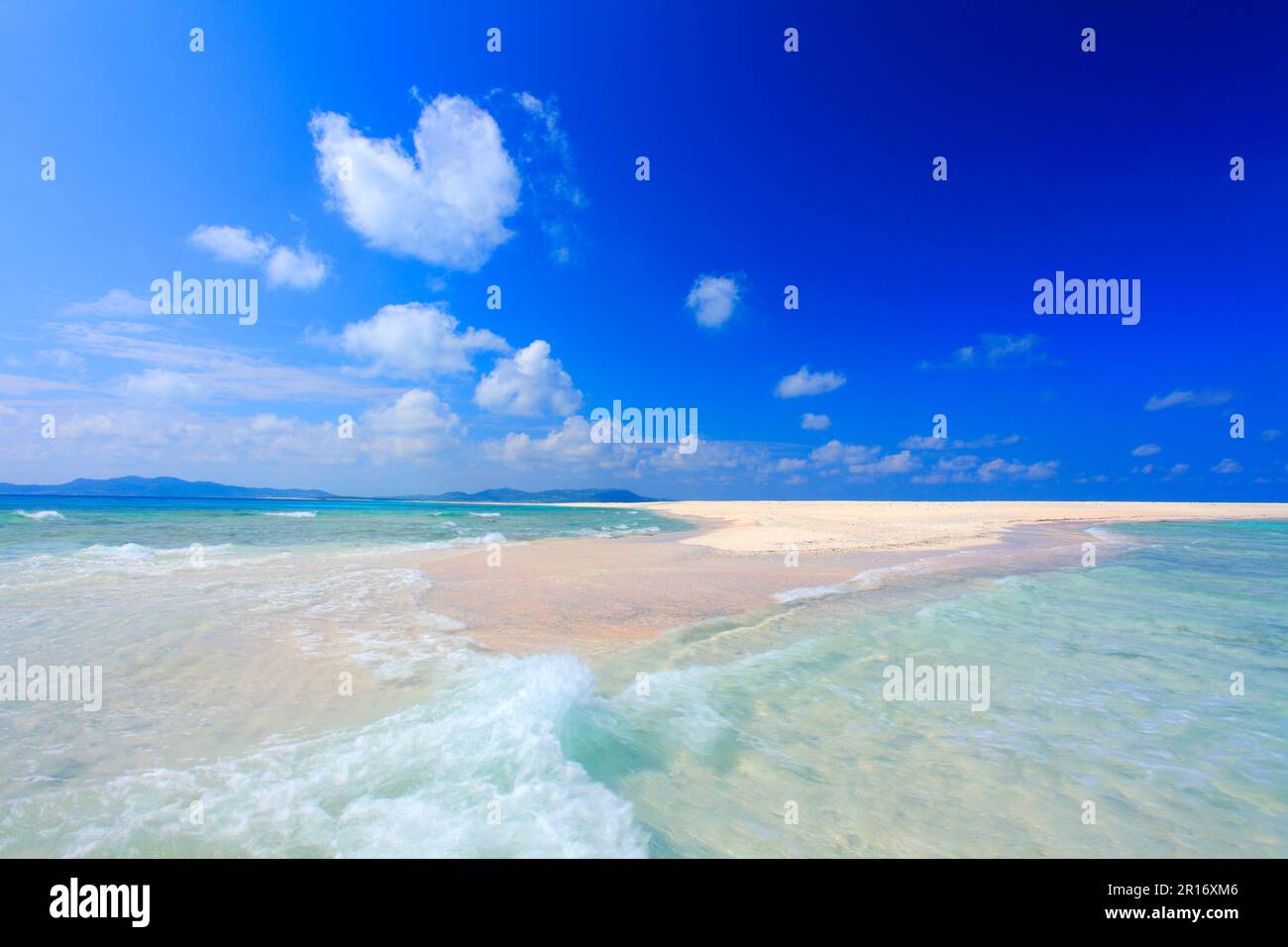 Intersecting sea spray, Hatenohama Beach and heart shaped clouds Stock Photo