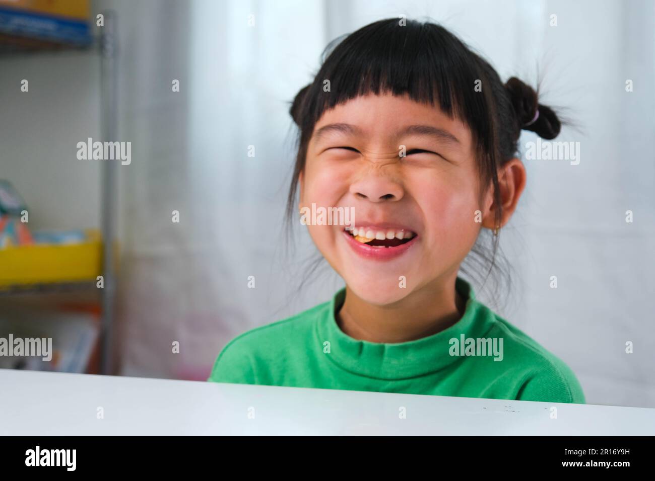 Happy cute little girl eating gelatin candy. Funny kid with chewing gum