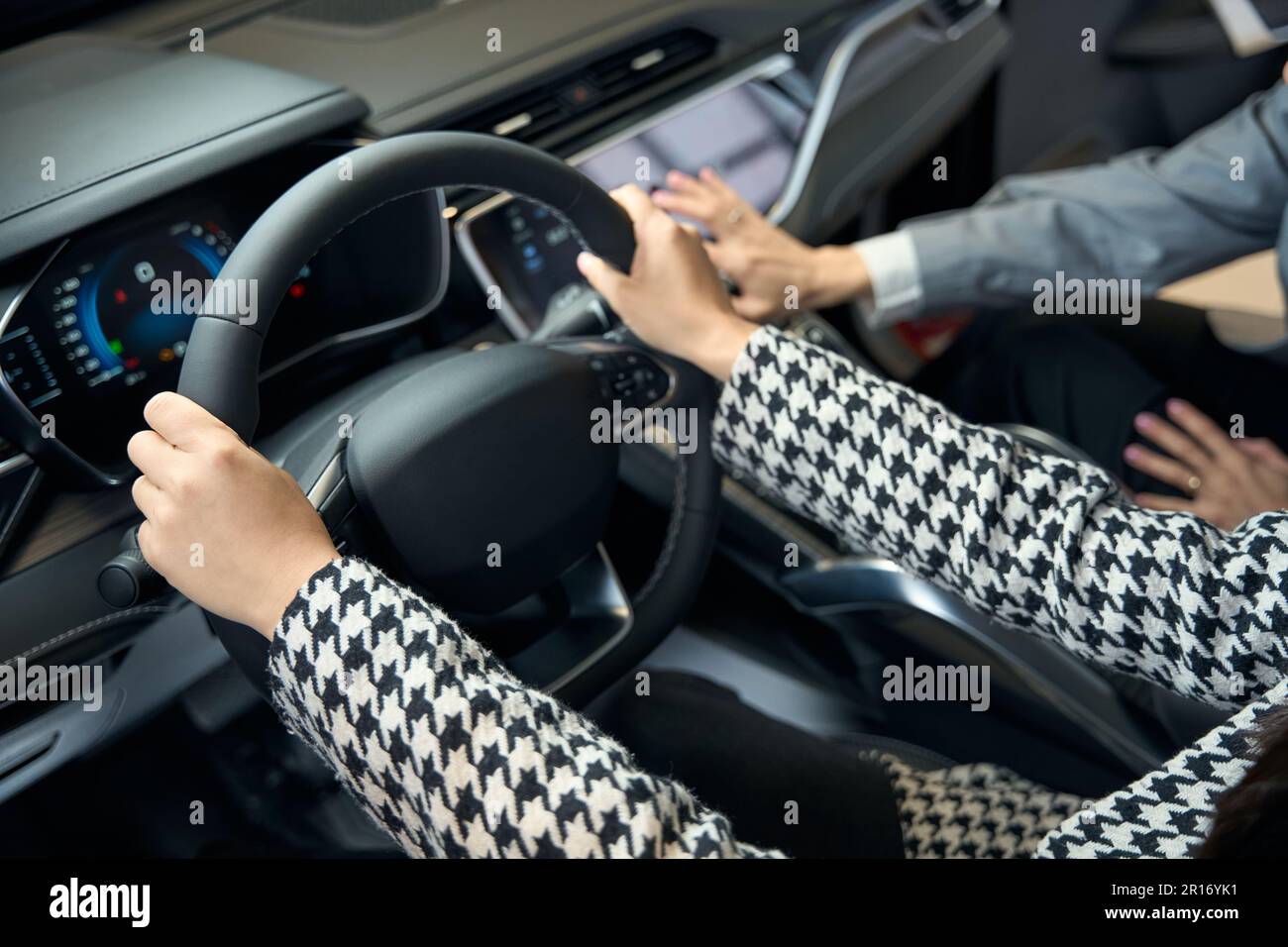 Female hands in a jacket on the steering wheel Stock Photo Alamy