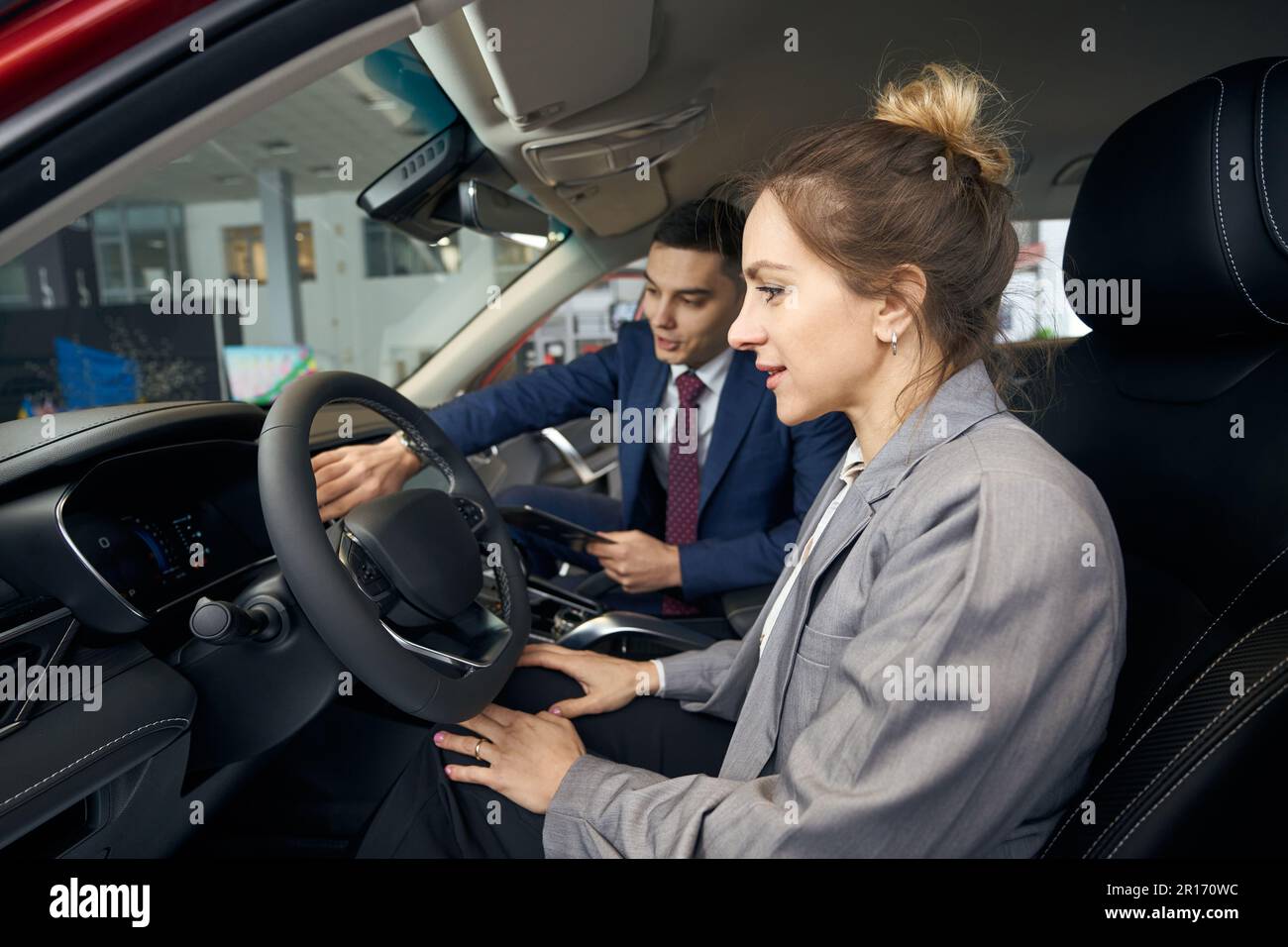 Man in suit showing woman control panel Stock Photo - Alamy