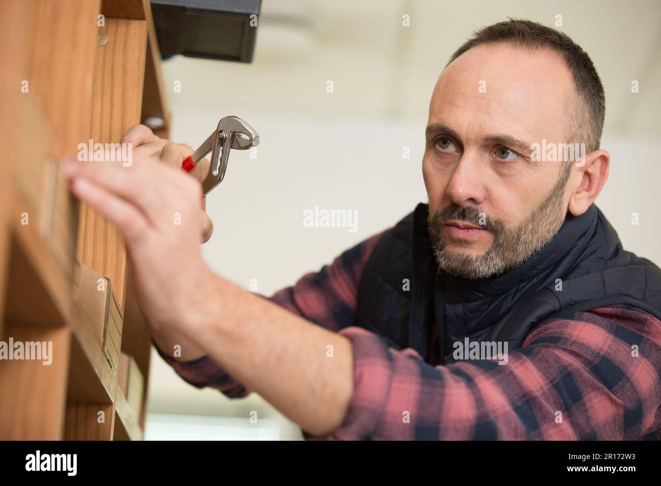 mature worker installing shelf Stock Photo Alamy