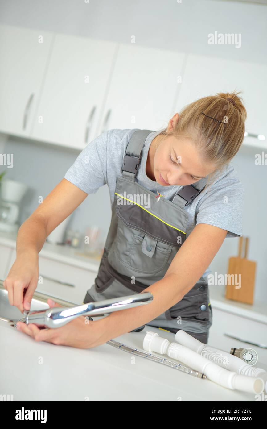female plumber installing a kitchen sink Stock Photo Alamy