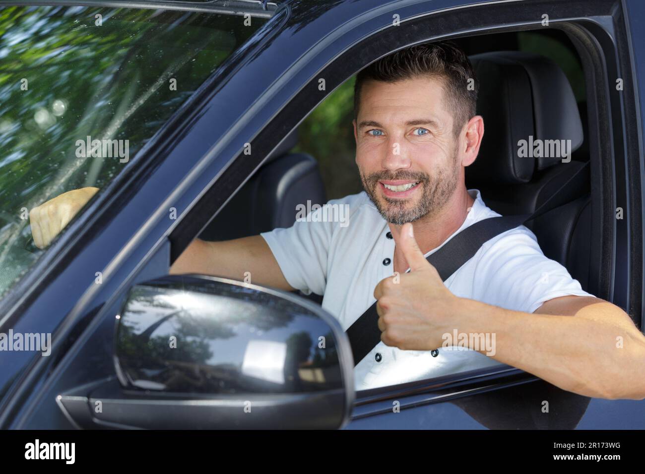 smiling successful man driving his new car with thumbs up Stock Photo ...