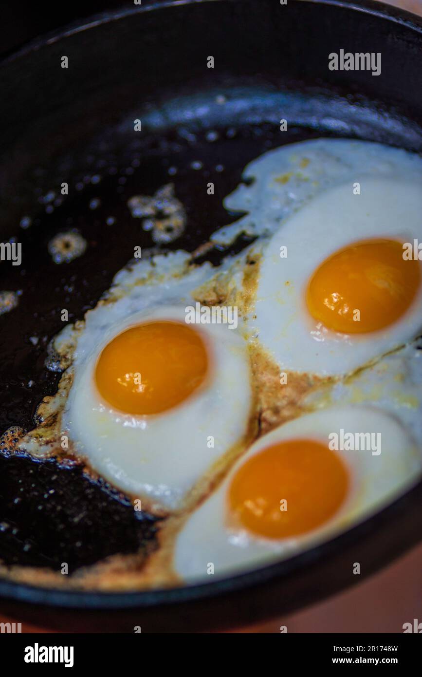 three eggs fried in frying pan scrambled eggs. Healthy food, nutritious