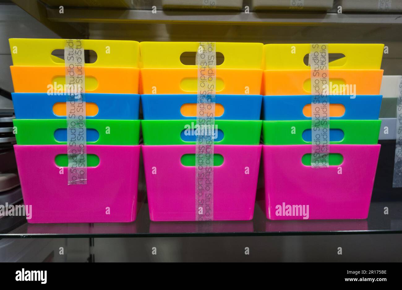 Brightly coloured plastic storage boxes on display in a shop in London, England, UK Stock Photo