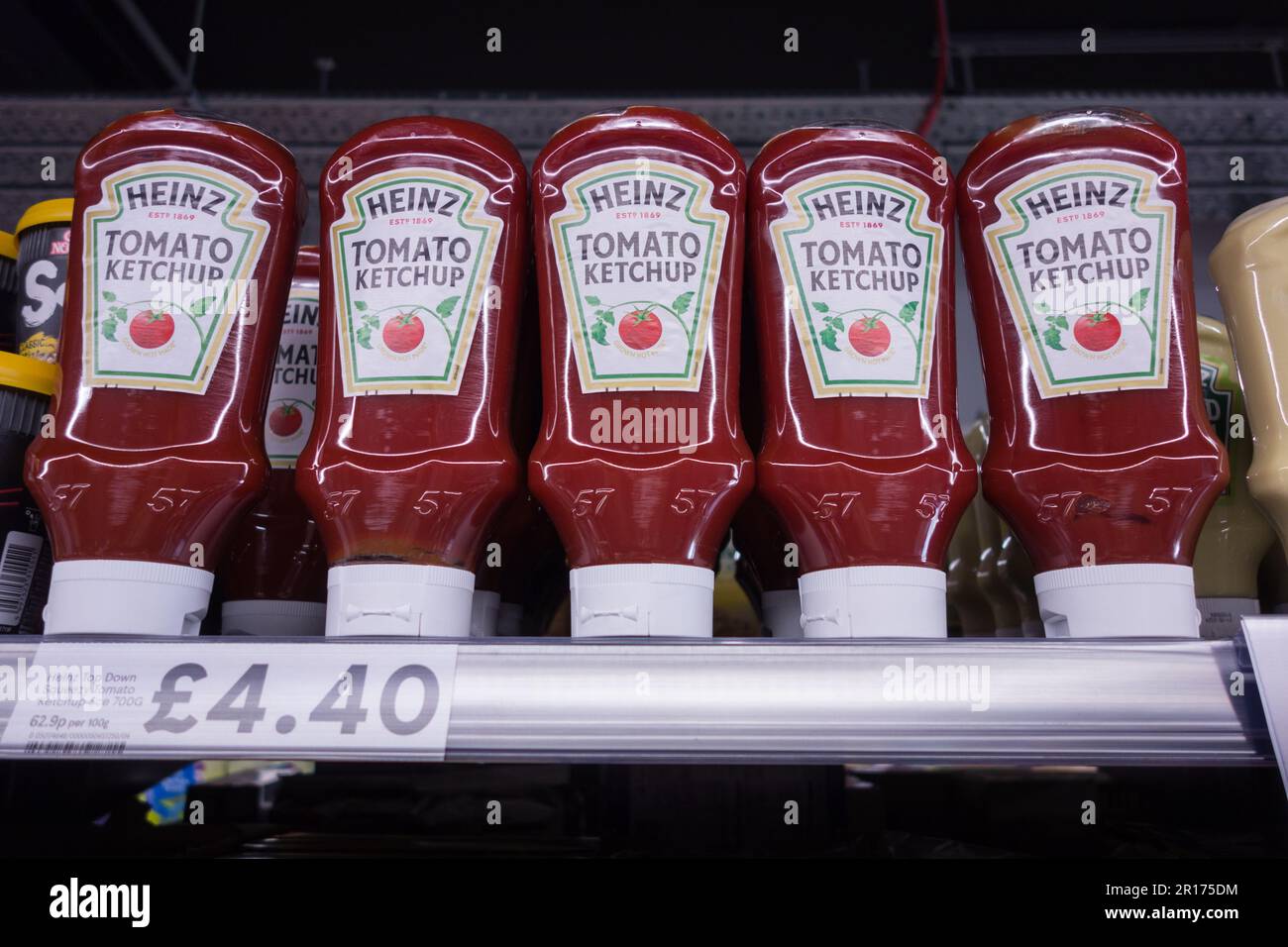 A row of Plastic Heinz Tomato Ketchup bottles on a supermarket shelf Stock Photo