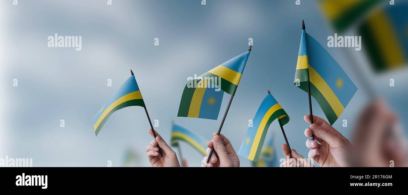A group of people holding small flags of the Rwanda in their hands ...