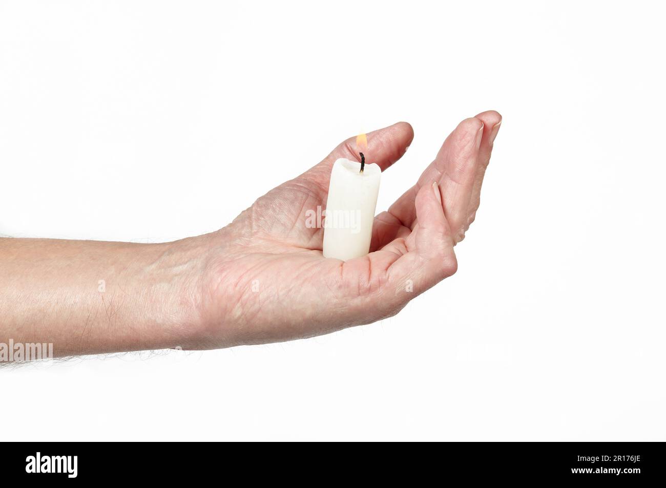 Men's hand holding a candle isolated white background. Man holding burning candle, closeup Stock