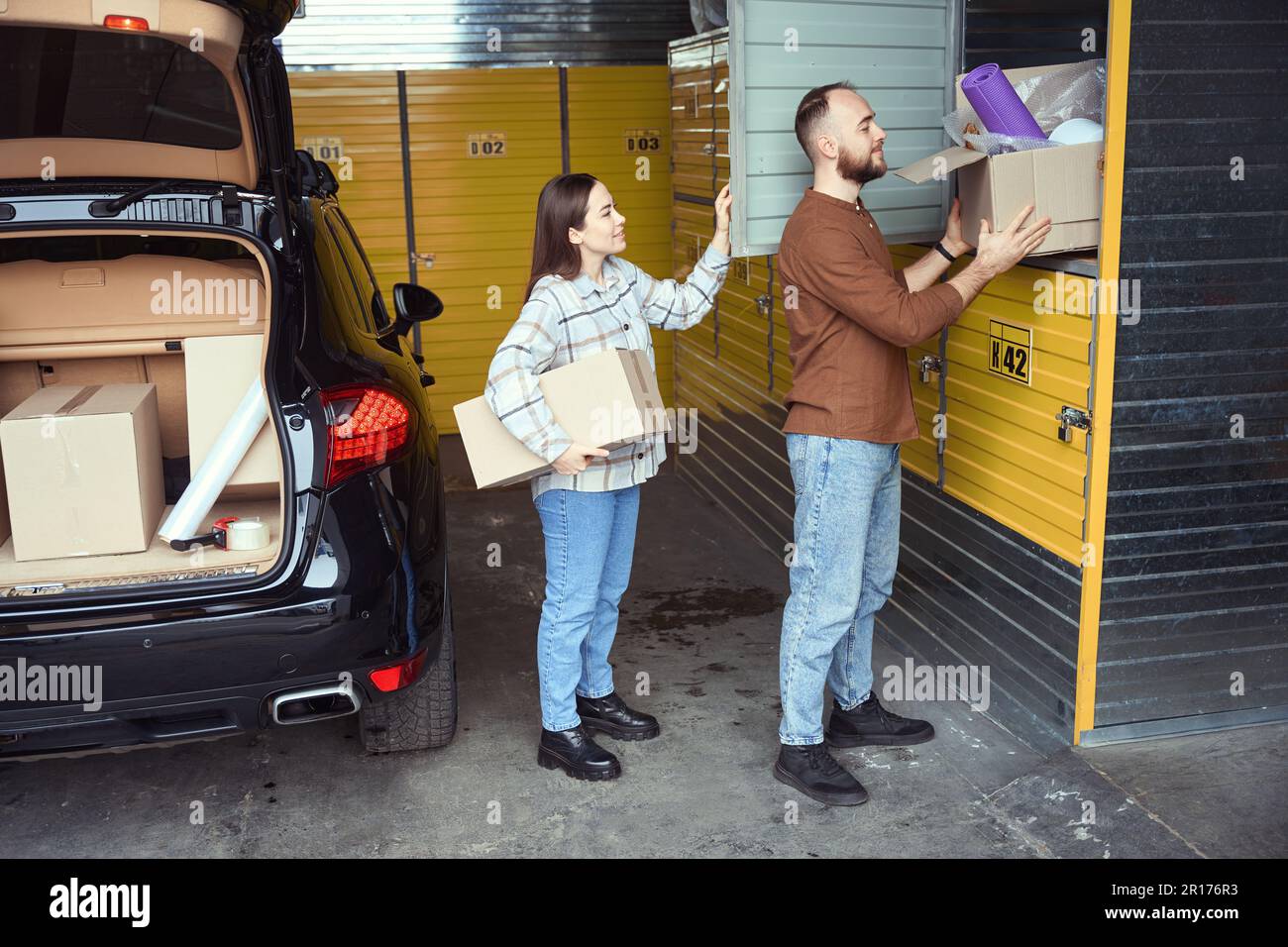 Happy grownup man and woman putting things in storage Stock Photo Alamy