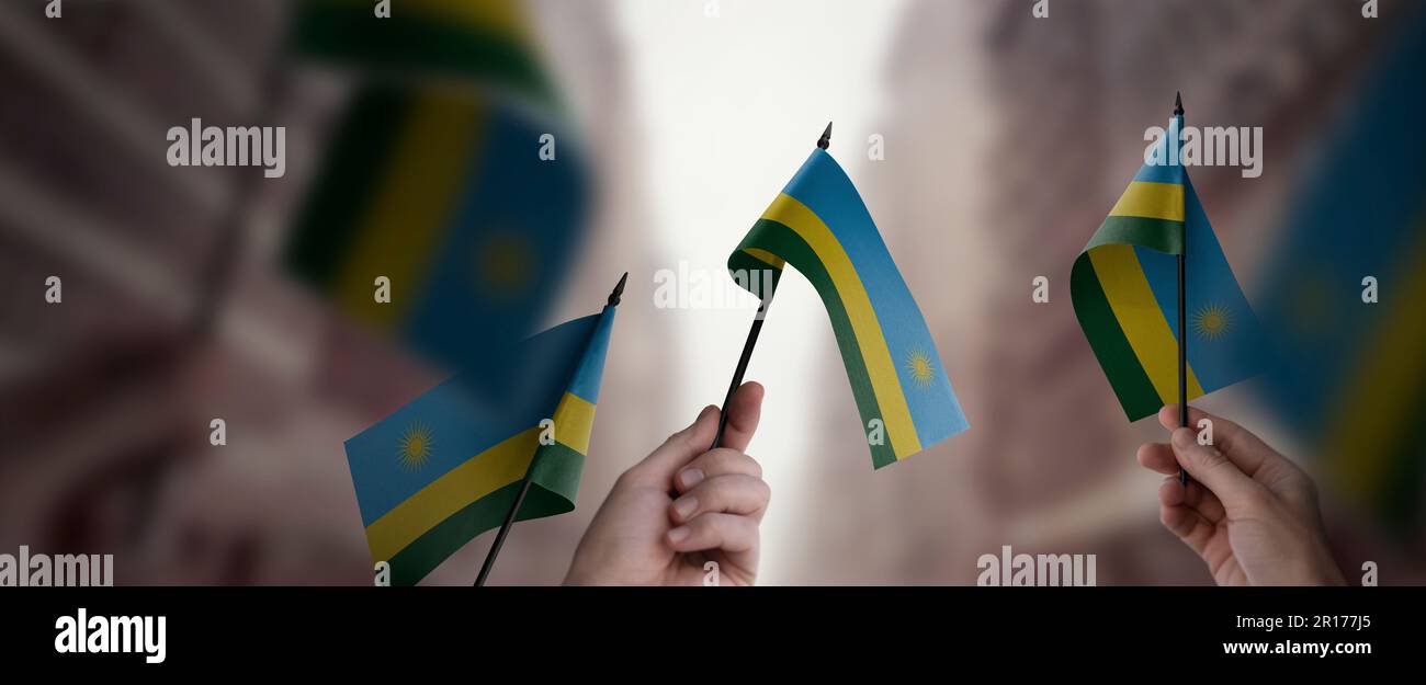 A group of people holding small flags of the Rwanda in their hands ...