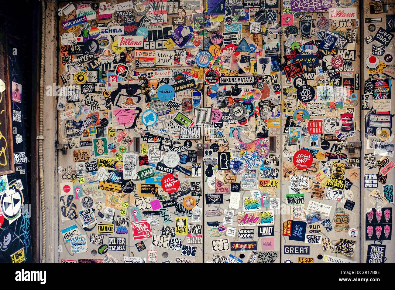 Multiple stickers covering a wall creating a montage style. Located down a japanese side street in Tokyo, Japan Stock Photo