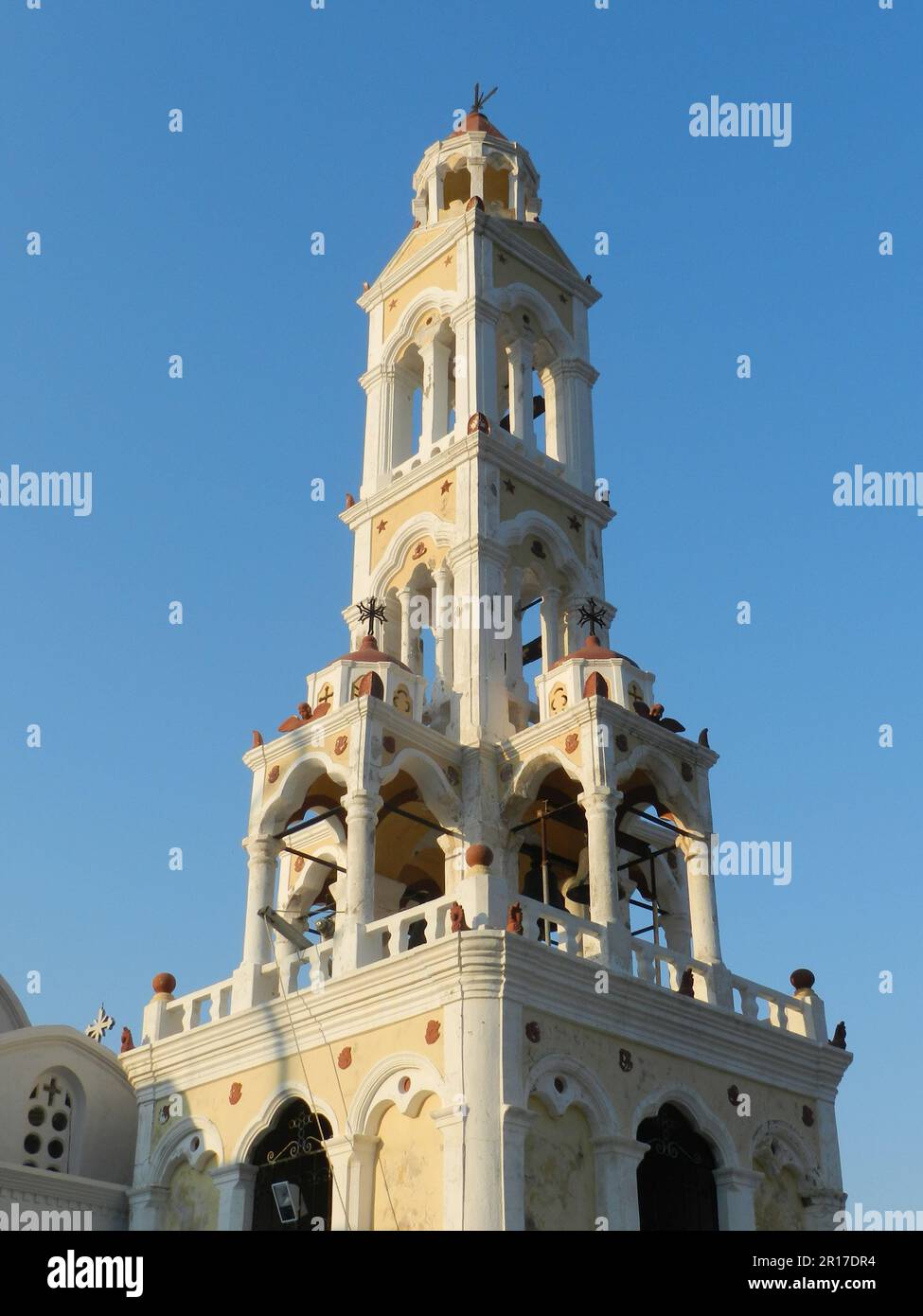 Greece, Island of Symi:  colourful belltower of an Orthodox church overlooking Symi port. Stock Photo