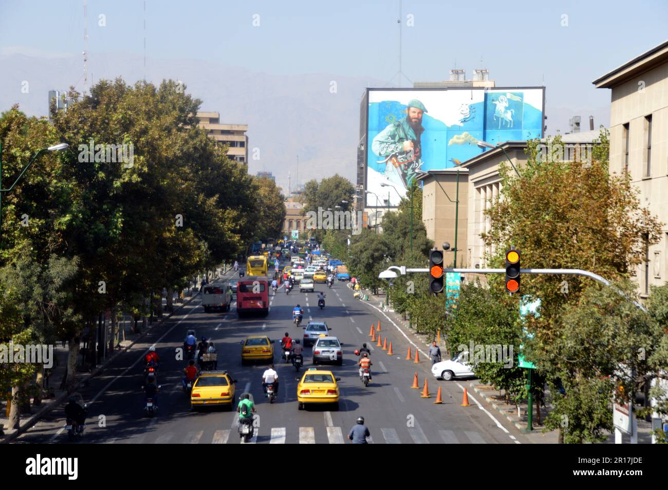 Iran, Teheran:   typical street scene with hoarding lauding a hero of the Iraq-Iran war. Stock Photo