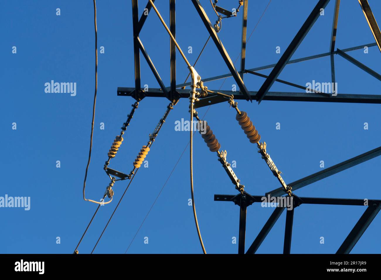 Steel mast of a high-voltage electric pole against the blue sky. Power ...