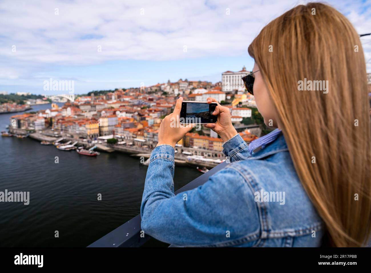 Young Woman Taking Pictures Of Porto Cityscape Stock Photo