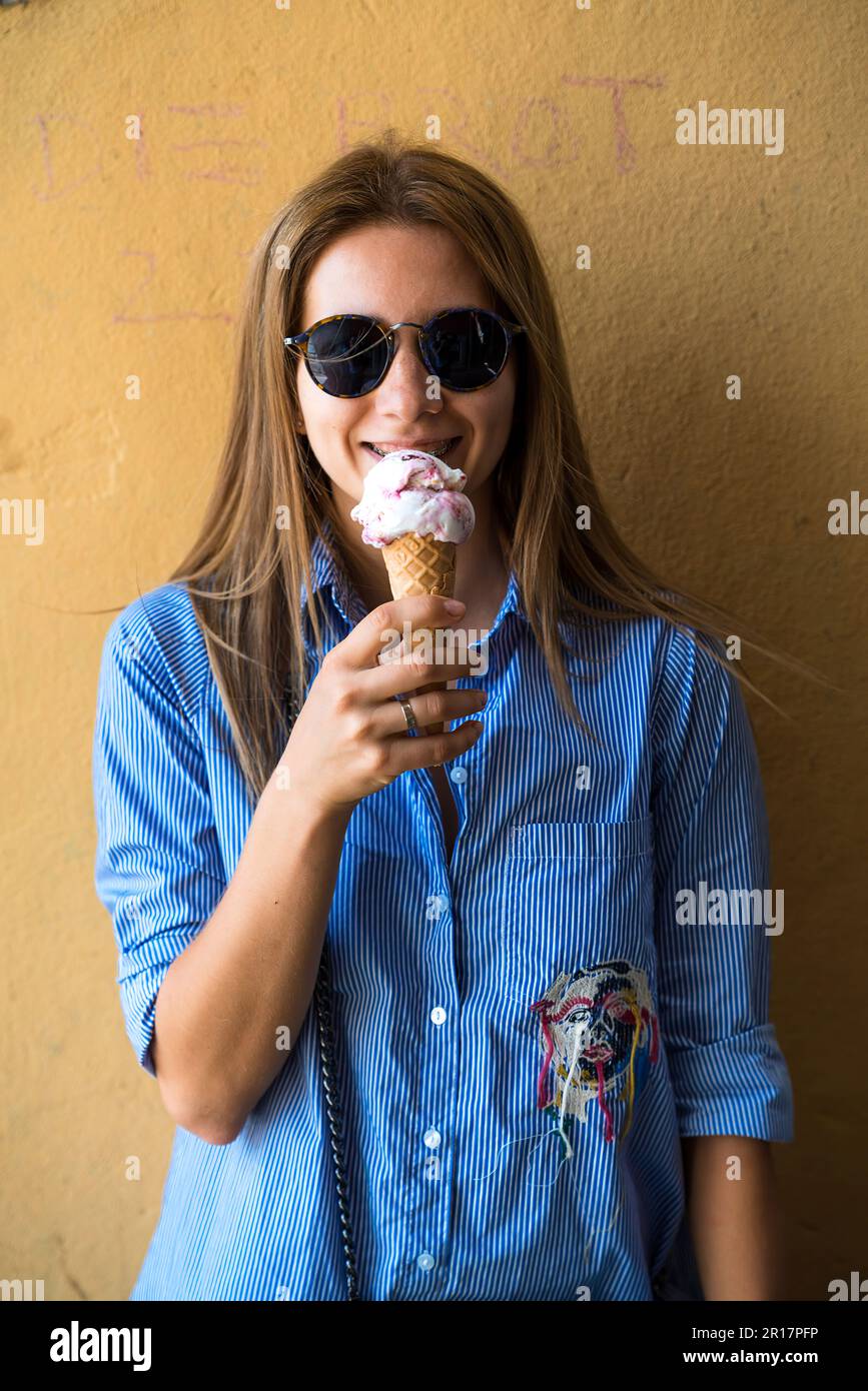 Woman in a blue dress eats ice corn and smiling Stock Photo - Alamy Woman in a blue dress eats ice corn and smiling Stock Photo - Alamy