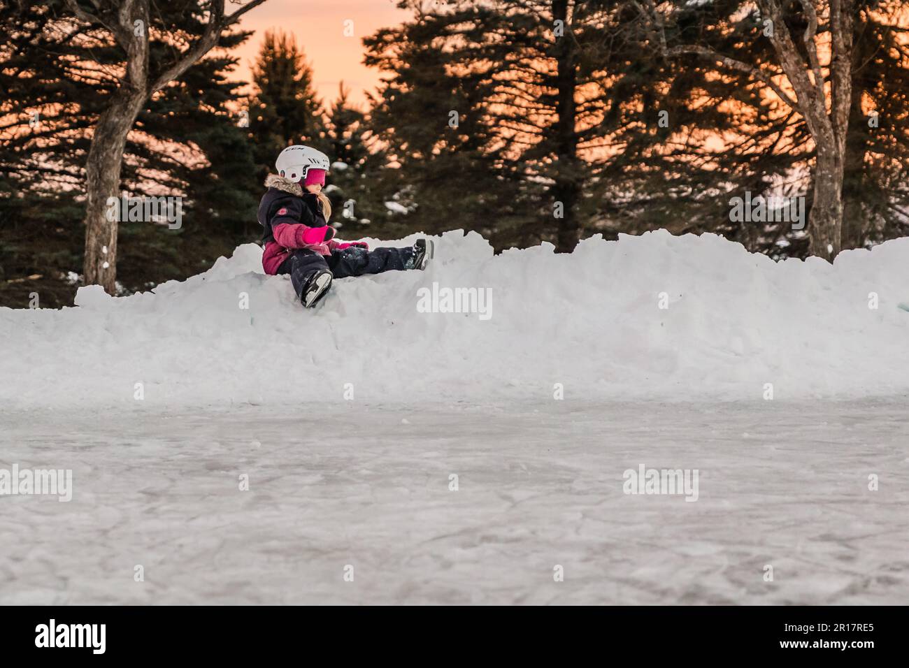 5 years old girl learning how to skate and resting Stock Photo