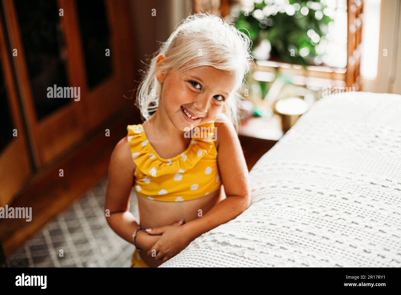 young blond girl smiling indoors Stock Photo